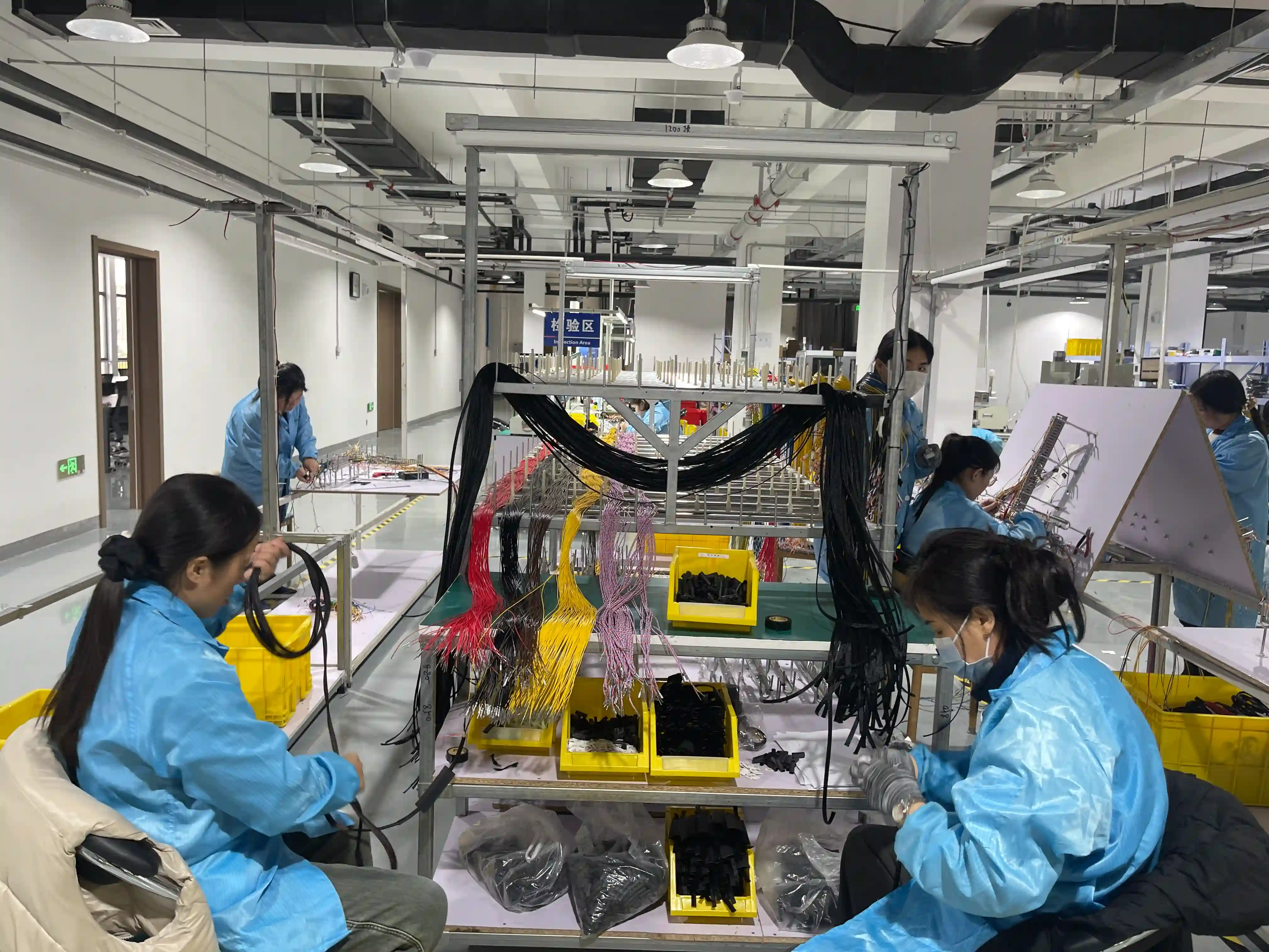 Wire harness production line with cable routing and bend radius management during manufacturing